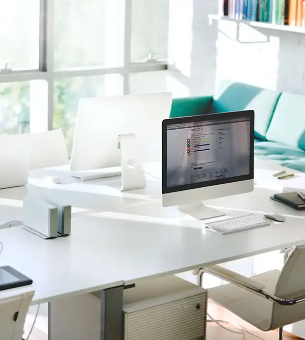 Computadores em mesa e sofá ao fundo. Coworking médico em São Paulo, clínica da Medical Place no Paraíso, em São Paulo.