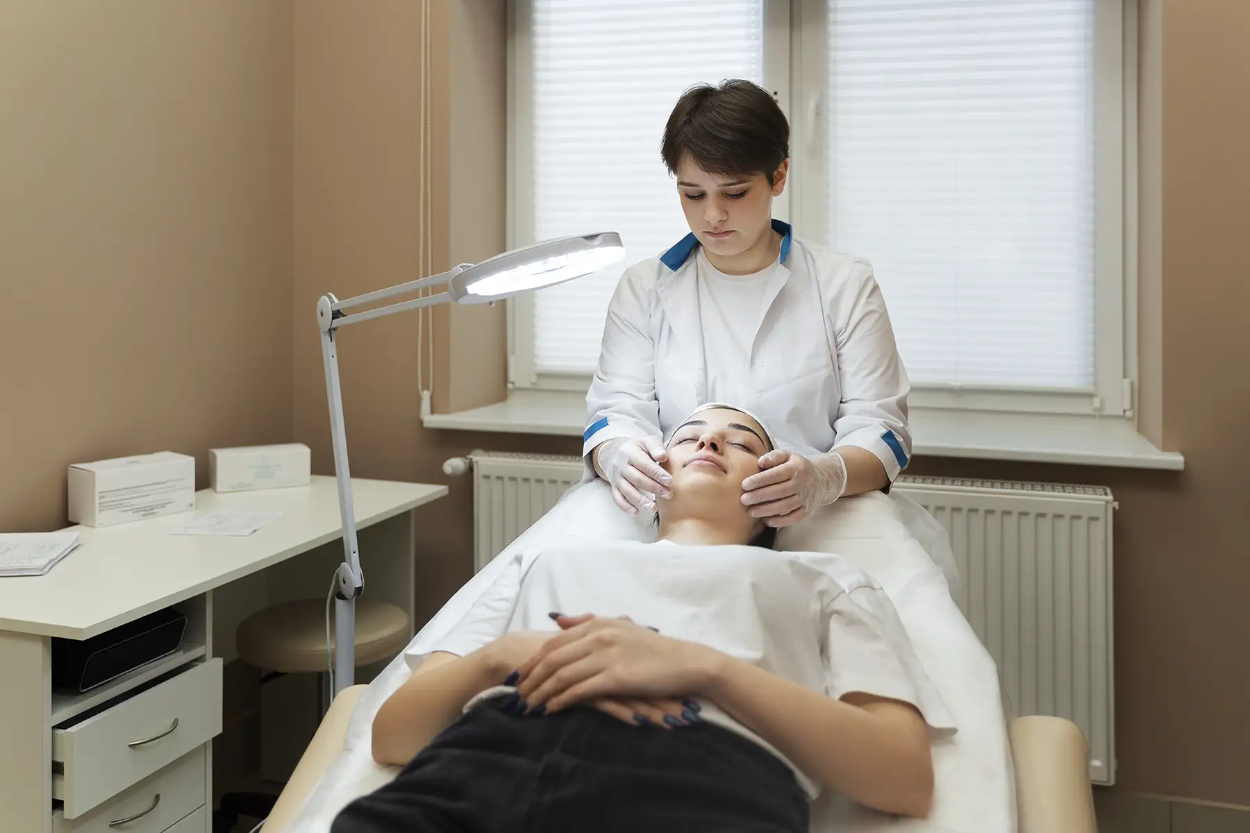 Dermatologista no Paraíso realizando avaliação facial em paciente durante consulta estética