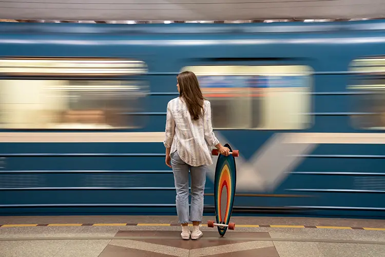 Mulher com skate colorido aguardando metrô. Consultório perto do metrô Paraíso com estação de metrô próxima